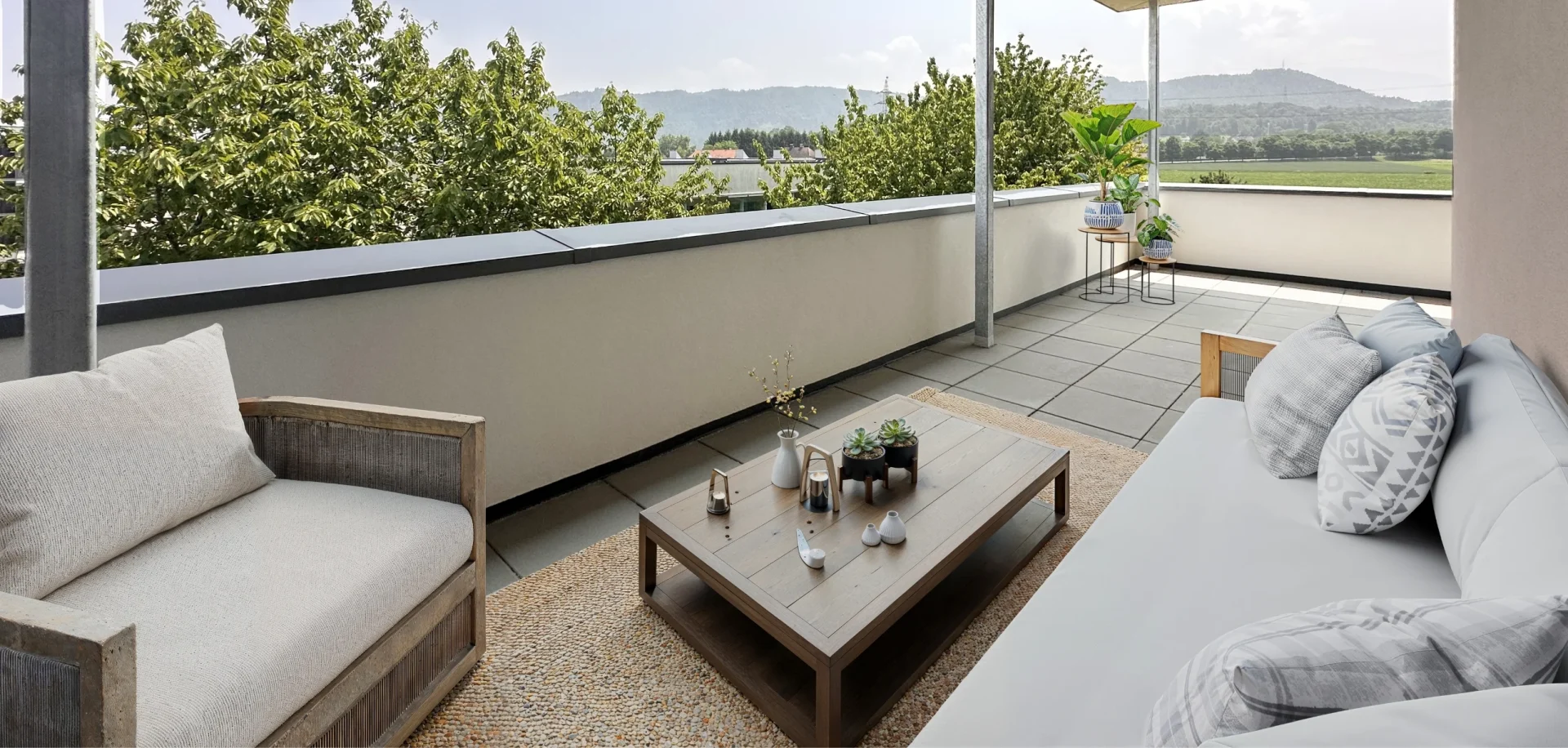 TRI_LageEntdecken_01 Möblierte Terrasse mit gemütlichen Sofas und Blick ins Grüne.
